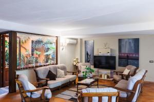 a living room with couches and a flat screen tv at Hotel Le Mura in Foligno