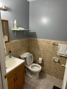 a bathroom with a white toilet and a sink at Guest House 3 BEDROOM 2 Bathrooms 5 MINS TO EWR NEWARK AIRPORT 4 MINS TO PENN STATION in Newark