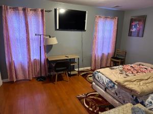 a bedroom with a bed and a desk and curtains at Guest House 3 BEDROOM 2 Bathrooms 5 MINS TO EWR NEWARK AIRPORT 4 MINS TO PENN STATION in Newark