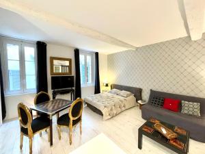 a living room with a couch and a bed and a table at Les Remparts Antibes Location in Antibes