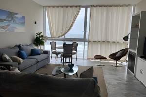 a living room with a couch and a table at Apto vista mar em Pitangueiras, Guarujá in Guarujá