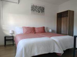 a bedroom with a large bed with pink pillows at Alojamento Andorinhas in Senhora da Hora