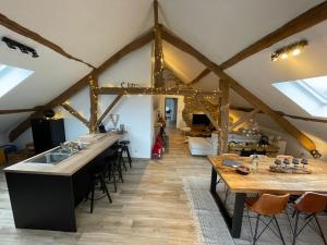 a kitchen with wooden beams and a dining room at Le grenier de Charlotte in Libin