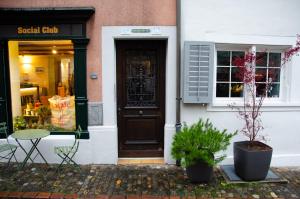 a door of a store with a table and a chair at MANY'S historical city central APARTMENTS in Zurich