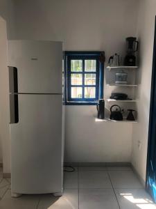 um frigorífico branco numa cozinha com uma janela em Morada Santa Pinheira em Palhoça