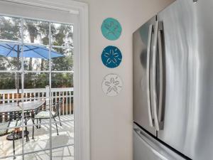 cocina con nevera y patio con mesa. en Peaceful Beach Vacation, Heated Pool Access, Walk to Restaurants & More!, en Tybee Island