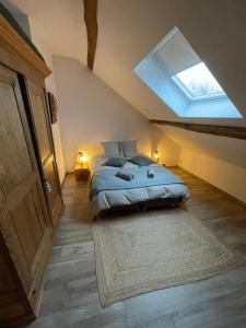 een slaapkamer met een bed en een dakraam bij Le grenier de Charlotte in Libin