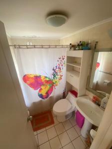 a bathroom with a butterfly shower curtain with a toilet at Casa en coquimbo in Coquimbo