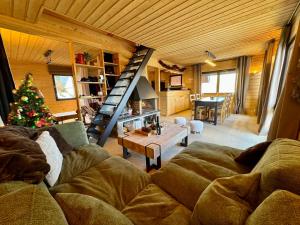 a living room with a couch and a christmas tree at Chalet St Lary Pla d'Adet in Saint-Lary-Soulan