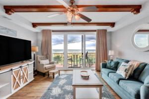 sala de estar con sofá y TV de pantalla plana en Oceanfront Condo with Gorgeous Views, 2 pools, Direct Beach Access, en Tybee Island