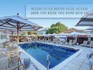 a swimming pool with chairs and umbrellas at North Tybee Beach Home, Near the Beach, Restaurants, Shops and More! Heated Pool Access in Tybee Island