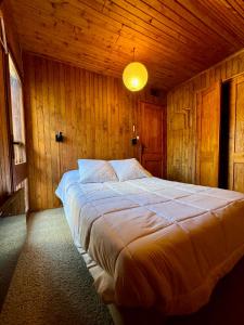 um quarto com uma cama grande num quarto de madeira em Chalet St Lary Pla d'Adet em Saint-Lary-Soulan