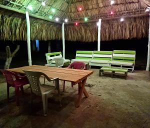 ein Picknicktisch und Stühle in einer Hütte in der Unterkunft Eco-Camping El Frutal in Isla Grande