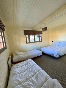 um quarto com três camas e uma janela em Chalet St Lary Pla d'Adet em Saint-Lary-Soulan