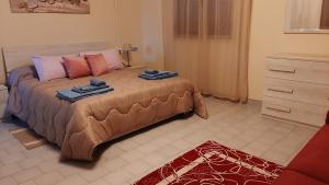 een slaapkamer met een groot bed en 2 handdoeken bij La casetta di Lore in Sassetta