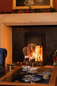 two glasses of wine on a table in front of a fireplace at Ard na Sidhe Country House Hotel in Killorglin