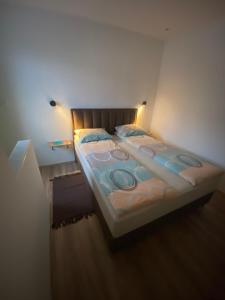 un letto in una stanza con una luce sopra di Blue Lagoon Apartments a Crni Vrh