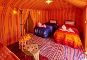 a bedroom with two beds in a tent at Desert Berber Fire-Camp in Merzouga