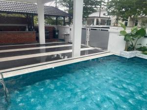 una piscina de agua azul frente a una casa en Bukit katil Villa Anjung Kaseh Peaceful 4 bedroom Villa With Swimming Pool, en Melaka