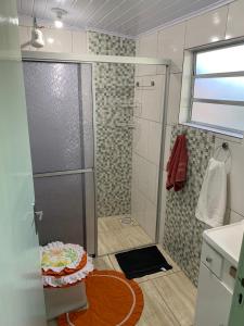 y baño con ducha y puerta de cristal. en Orange House Canela, en Canela
