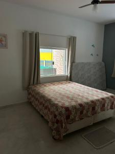 a bedroom with a bed and a window at Recanto mato verde in Caraguatatuba