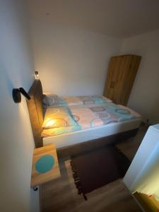 1 dormitorio con cama y silla de madera en Blue Lagoon Apartments en Crni Vrh