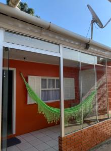 una hamaca verde colgada del lateral de un edificio en Orange House Canela, en Canela