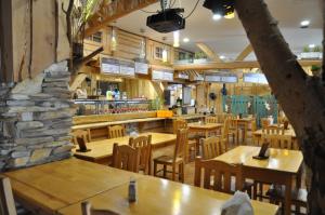 a restaurant with wooden tables and wooden chairs at Willa Marin in Karwia
