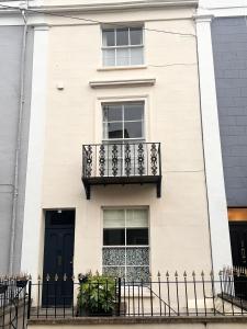 a white house with a black balcony at Lido Townhouse in Bristol