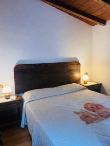 - une chambre avec un lit avec une tête de lit en bois et deux lampes dans l'établissement Il Colle - Apartment Giglio, à Florence