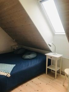 a bedroom with a blue bed in a attic at Arnhög Farm in Borrby