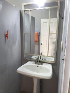 a bathroom with a sink and a mirror at Beach Club Budget Rooms at Popeyes Caye Caulker in Caye Caulker