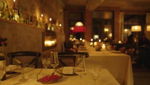 a table in a restaurant with wine glasses on it at Ati Ambavi Botique Hotel Gudauri in Gudauri