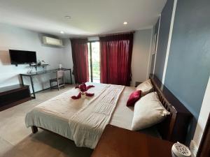 ein Schlafzimmer mit einem großen Bett mit roten Bögen darauf in der Unterkunft Grandmom Place in Krabi