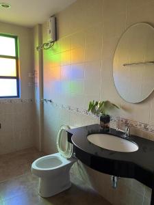 a bathroom with a sink and a toilet and a mirror at Grandmom Place in Krabi