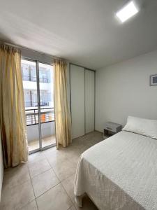 um quarto com uma cama e uma grande janela em Alojamiento confortable para tus días en Córdoba. em Córdoba