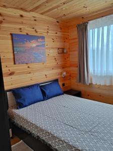 een slaapkamer met een bed in een blokhut bij Вили Таормина и Месина in Chernomorets