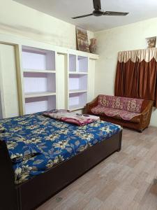 een slaapkamer met een bed en een bank bij JPM Hostel in Varanasi