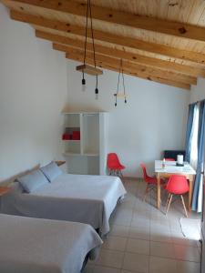プエルト・サン・フリアンにあるG&D Departamentosのベッド2台とテーブルと椅子のある寝室
