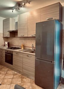 eine Küche mit einem Kühlschrank und Schränken aus Edelstahl in der Unterkunft Appartamento accogliente con terrazzo panoramico in Telese
