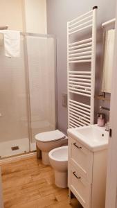 y baño blanco con aseo y ducha. en Casanova Trieste Centrale, en Trieste