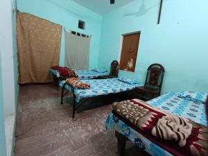 two beds in a room with blue walls at JPM Hostel in Varanasi
