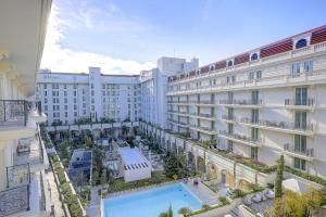 戛纳Carlton Riviera Cannes的享有酒店正面景色,设有游泳池和建筑