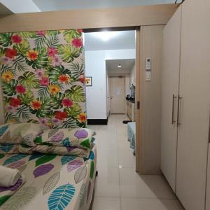 sypialnia z łóżkiem z wzorem kwiatowym w obiekcie Phert's apartment w mieście Manila