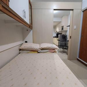 mały pokój z łóżkiem i kuchnią w obiekcie Phert's apartment w mieście Manila