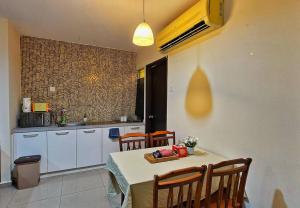 a kitchen with a table and chairs and a kitchen with a sink at Laguna 1, Marina Island by TZ Homestay in Lumut