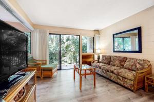 a living room with a couch and a tv at Hono Kai B17 in Wailuku