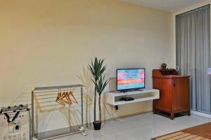 a living room with a tv on a desk with a plant at Laguna 1, Marina Island by TZ Homestay in Lumut