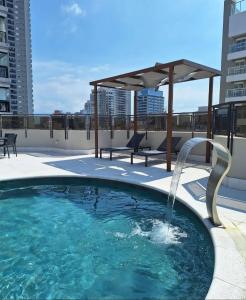 a swimming pool with a fountain on the roof of a building at Lindo Flat no Gonzaga, com GARAGEM e PISCINA in Santos