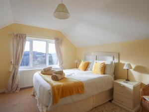 a bedroom with a large bed with towels on it at Glan Gors in Llandyfrydog
